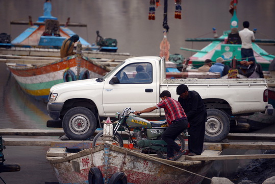 In this photograph taken on on August 3, 2015, Pakistani residents load a motorbike onto a boat used to cross Attabad Lake, which was formed following a landslide in January 2010, in Pakistan's Gojal Valley. Karachi, 2050: The sprawling megacity lies crumbling, dessicated by another deadly heatwave, its millions of inhabitants suffering life-threatening water shortages and unable to buy bread that has become too expensive to eat. It sounds like the stuff of dystopian fiction but it could be the reality Pakistan is facing. With its northern glaciers melting and its population surging -- the country's climate change time bomb is already ticking. AFP PHOTO / Aamir QURESHI