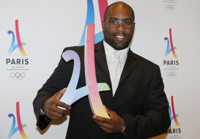 French judoka Teddy Riner poses with the logo of Paris as candidate for the 2024 Olympic summer games during a press conference in Paris on February 17, 2016. The race to host the 2024 Olympic Games gets underway in earnest today with the four bid cities -- Budapest, Los Angeles, Paris and Rome -- presenting their initial candidature files to the International Olympic Committee (IOC).