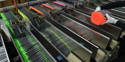 An employee of the German pencil maker Staedtler picks up the pencils out of a machine, in a production hall of the company in Nuremberg