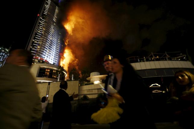 People run away as a fire engulfs The Address Hotel in downtown Dubai in the United Arab Emirates December 31, 2015. REUTERS/Ahmed Jadallah