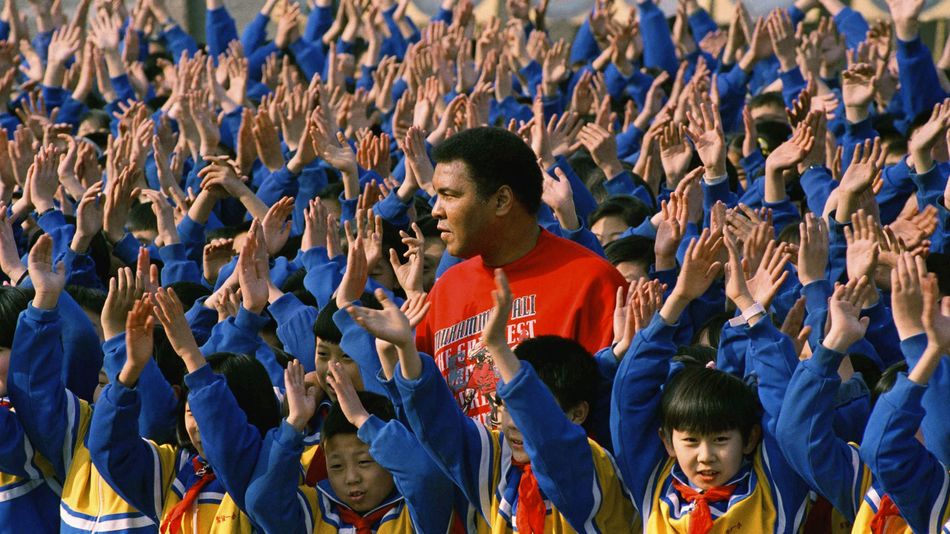 Muhammad Ali surrounded by hundreds of Chinese school children during a visit to the Beijing No. 1 Experimental Primary School in Beijing, China, 1993.