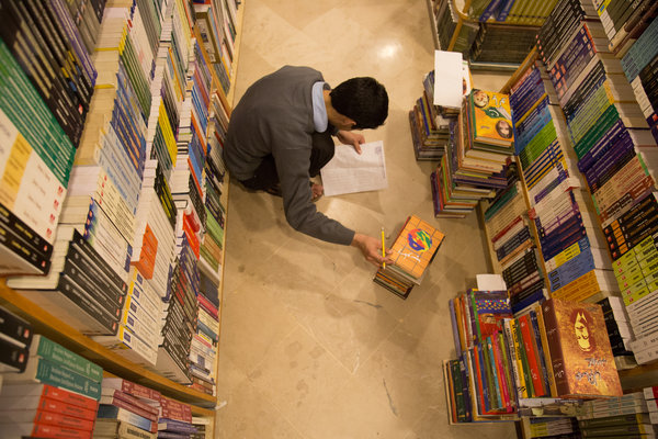 A salesman at Saeed Book Bank sorted volumes according to genre. Credit: Danial Shah for The New York Times
