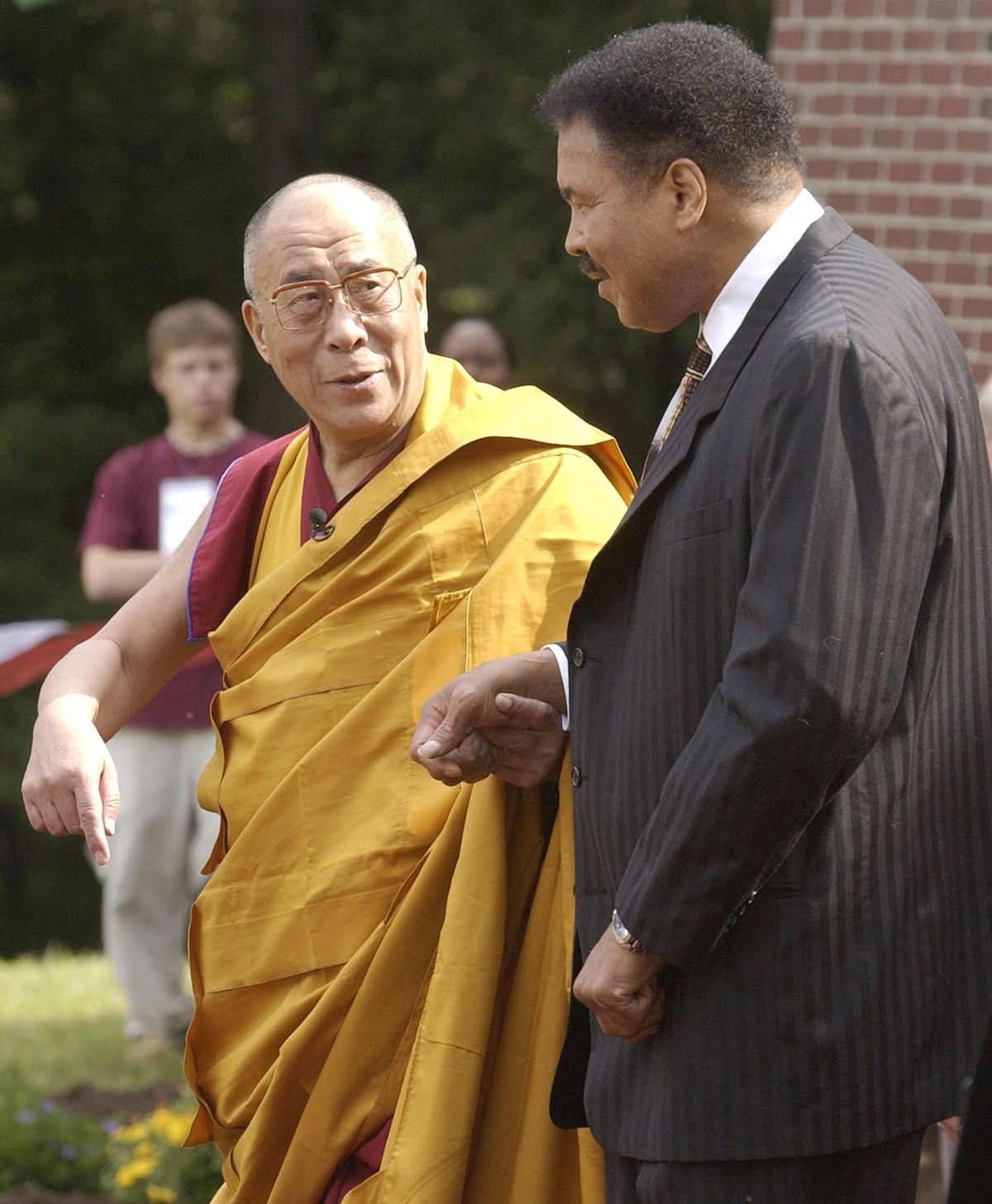 The Dalai Lama walks with Ali as they move towards a new interfaith temple at the Tibetan Cultural Center in Bloomington, Indiana, 2003.