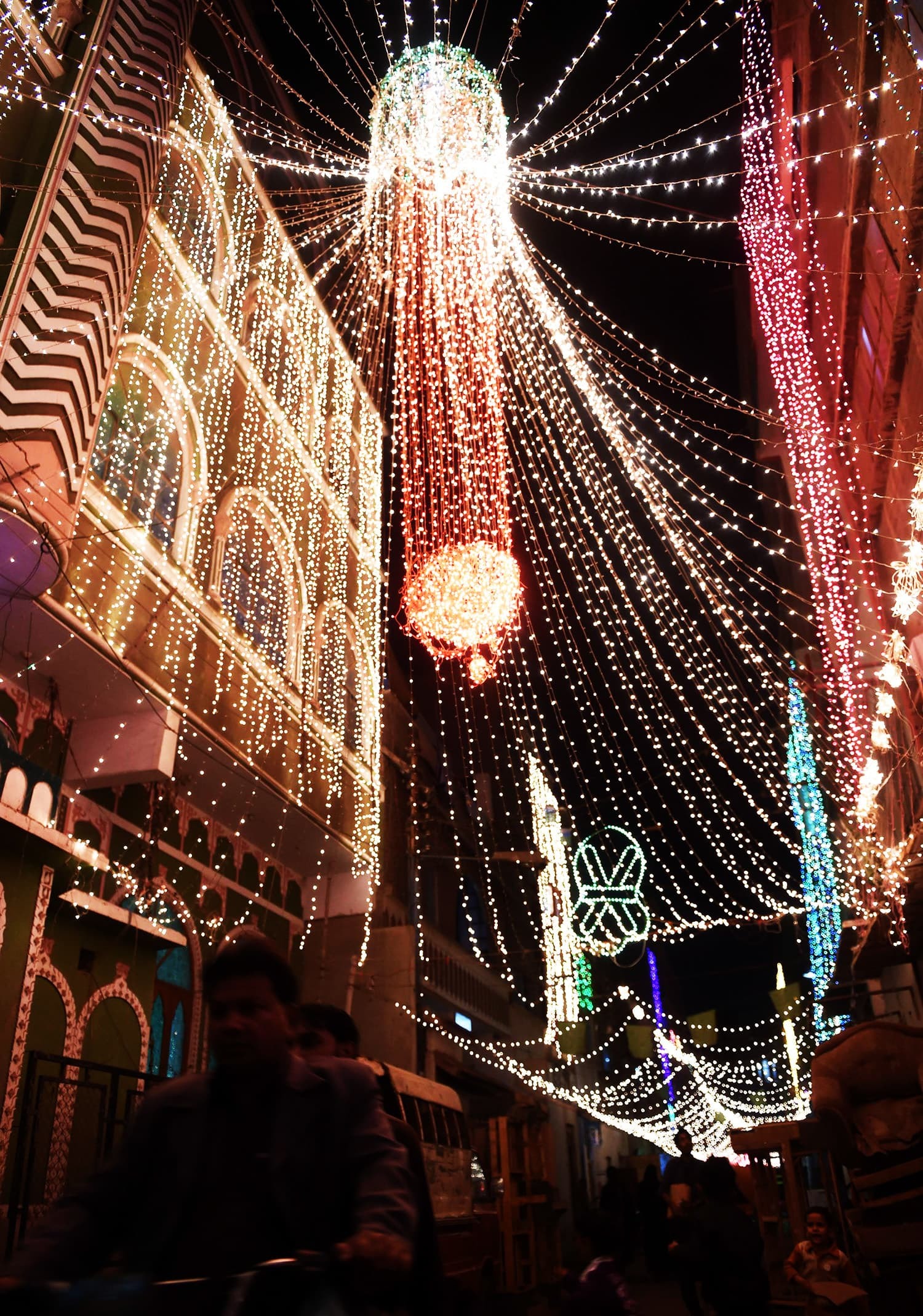 Pakistani men ride past a mosque decorated to celebrate the birthday of Prophet Mohammed in Karachi on December 23, 2015. The birthday of Prophet Mohammed, also known as 'Milad', is celebrated during the Islamic month of Rabi al-Awwal, which falls on December 24, 2015 in Pakistan. AFP PHOTO / Rizwan TABASSUM