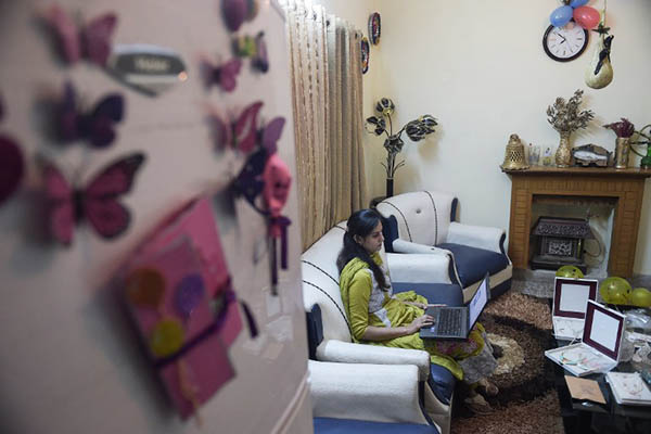TO GO WITH 'Pakistan-Economy-Internet-Commerce' FOCUS by Masroor GILANI This photograph taken on November 18, 2015 shows Pakistani Nosheen Kashif, an employee of online marketplace company Kaymu, working on a laptop at her residence in Islamabad. Women are seeing the benefits, but e-commerce presents potentially an even greater opportunity for young people in a country where roughly two thirds of the population -- of around 200 million -- are estimated to be under the age of 30. A recent economic survey by the finance ministry singled out the challenges facing youth in Pakistan, including "limited job search expertise, a mismatch between education, aspirations and employers' requirements and a lack of mobility, among other factors". AFP PHOTO / Aamir QURESHI / AFP / AAMIR QURESHI