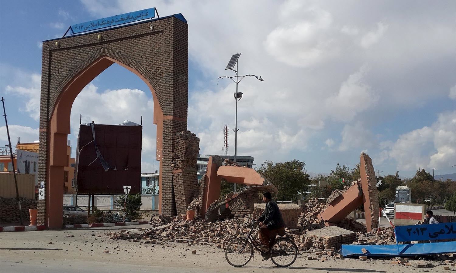 A man rides his bicycle next to damaged structures, after an earthquake in Ghazni, Afghanistan October 26, 2015. A powerful earthquake struck a remote area of northeastern Afghanistan on Monday, shaking the capital Kabul, as shockwaves were felt in northern India and in Pakistan's capital, where hundreds of people ran out of buildings as the ground rolled beneath them. REUTERS/Stringer  EDITORIAL USE ONLY. NO RESALES. NO ARCHIVE