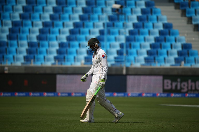 Pakistan's Mohammad Hafeez walks from the pitch after he was dismissed during the first day of the second Test cricket match between Pakistan and England in Dubai on October 22, 2015.       AFP PHOTO/MARWAN NAAMANI
