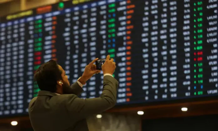 Man taking a photograph of the charts of the Pakistan Stock Exchange