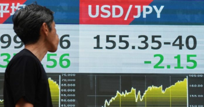 A financial monitor in Tokyo showing the US dollar to Japanese yen exchange rate (USD/JPY) and live foreign exchange market movements.