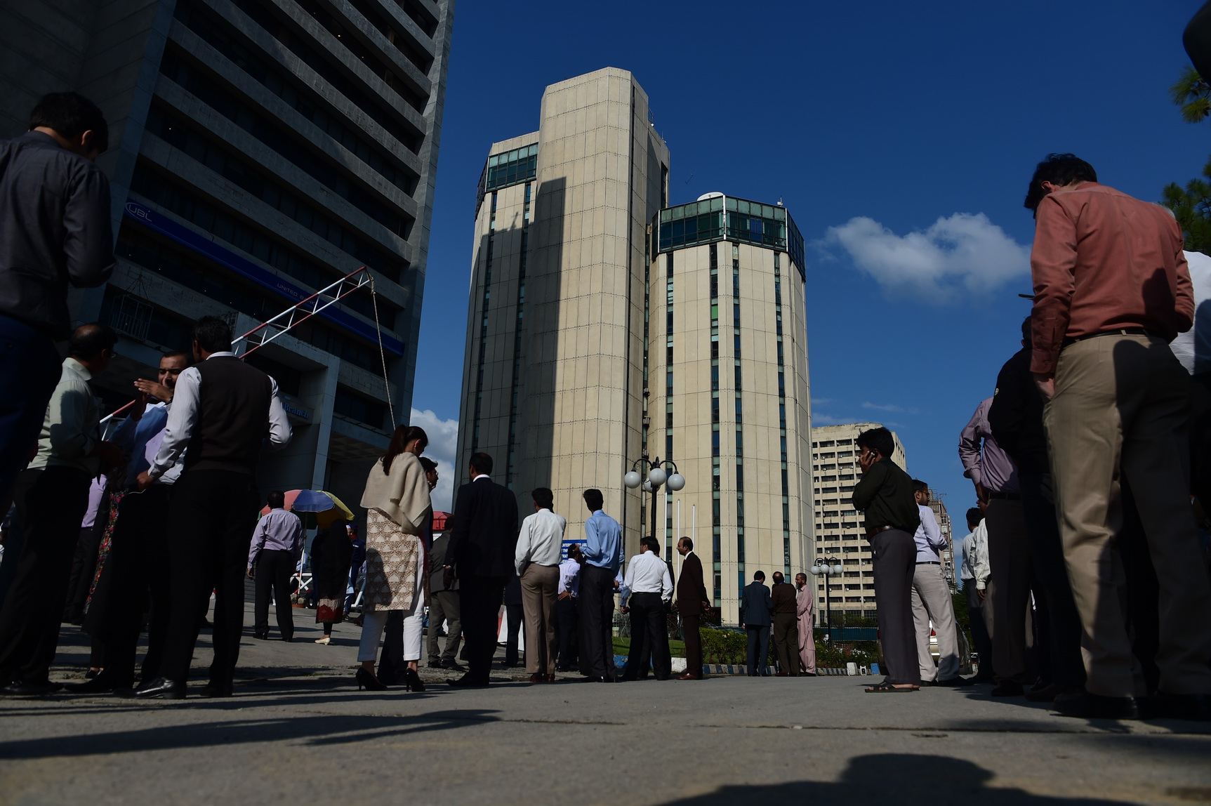 Pakistani federal employees gather outside their offices after a 7.5-magnitude earthquake in Islamabad on October 26, 2015. A powerful 7.5 magnitude quake struck Afghanistan's Hindu Kush region on October 26 and was felt throughout much of South Asia, injuring more than 100 people in neighbouring Pakistan according to a doctor. AFP PHOTO / Farooq NAEEM